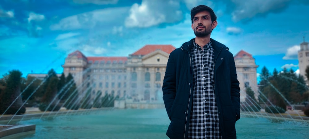 a man standing in front of a fountain