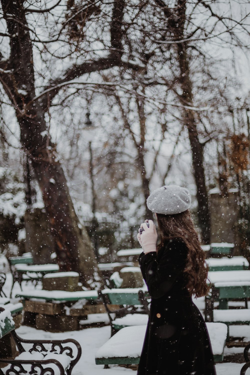 a woman standing in the snow in a park
