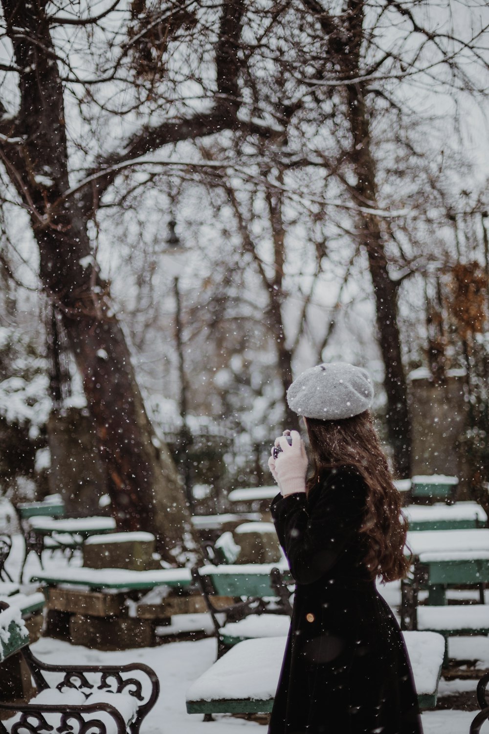 公園の雪の中に立つ女性