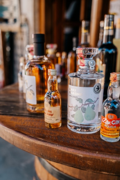 a wooden table topped with bottles of alcohol