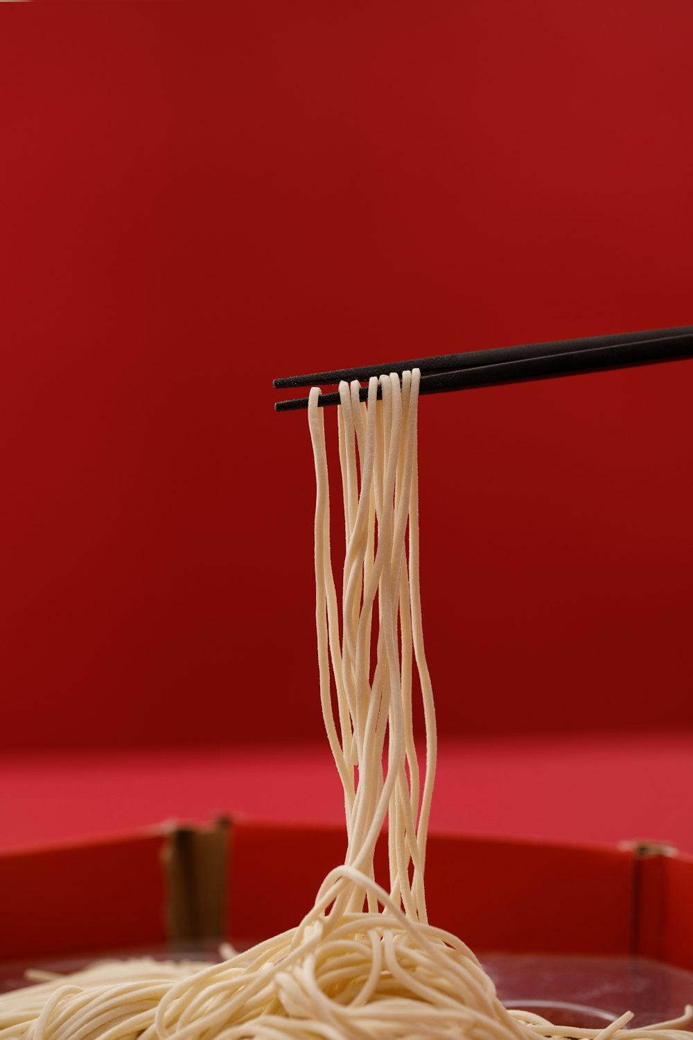 a bowl of noodles with chopsticks sticking out of it