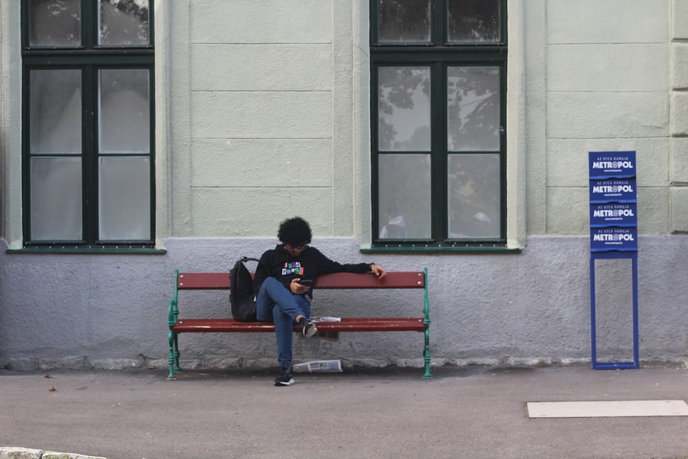 a person sitting on a bench in front of a building