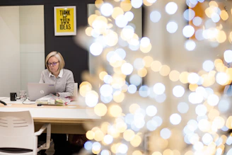 A professional woman working thoughtfully at her desk with marketing materials and a laptop, symbolizing strategic creativity.