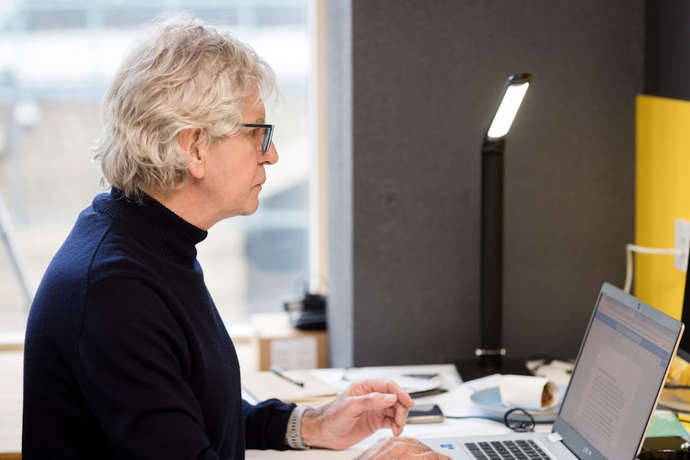 a woman sitting in front of a laptop computer