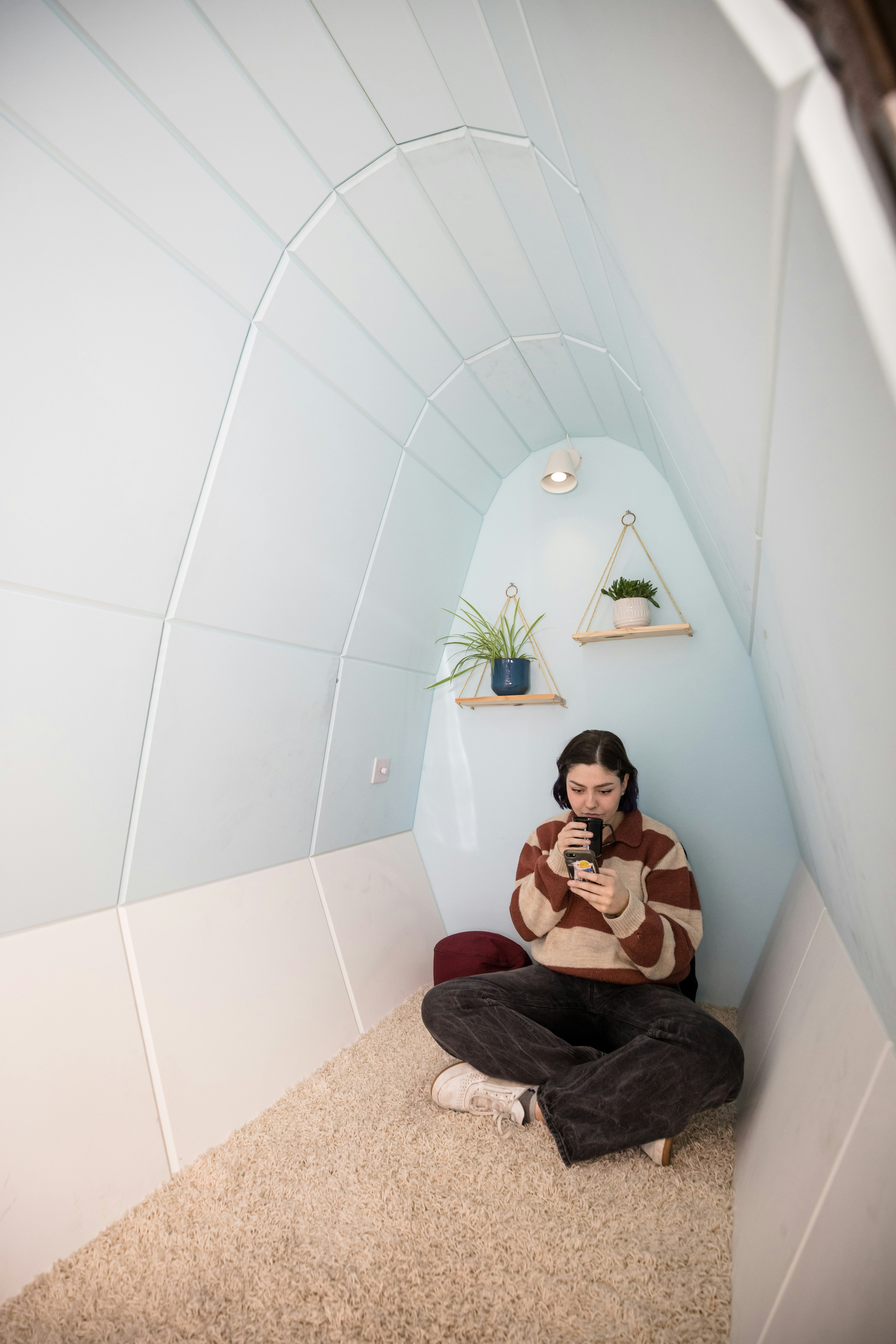 a woman sitting on the floor using a cell phone