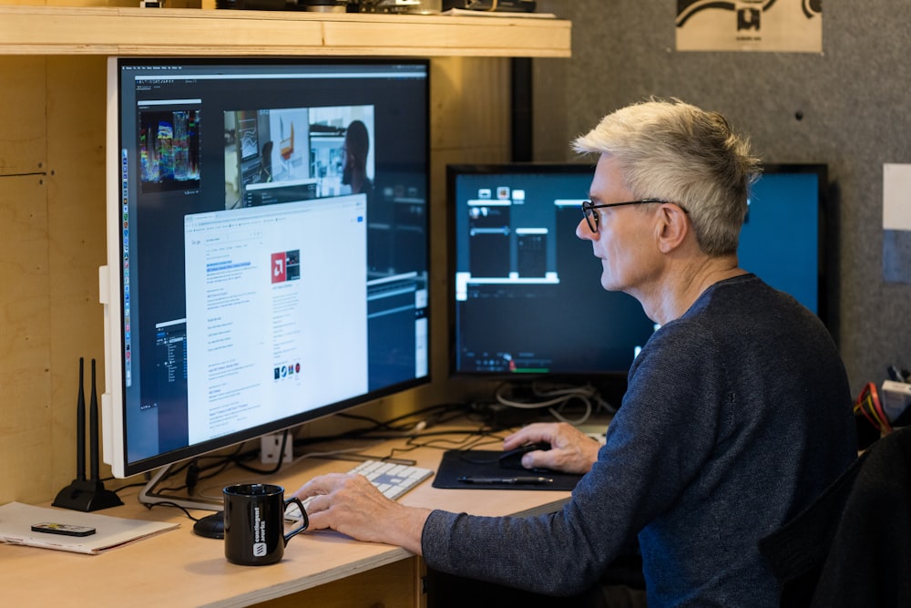 a man sitting in front of a computer monitor