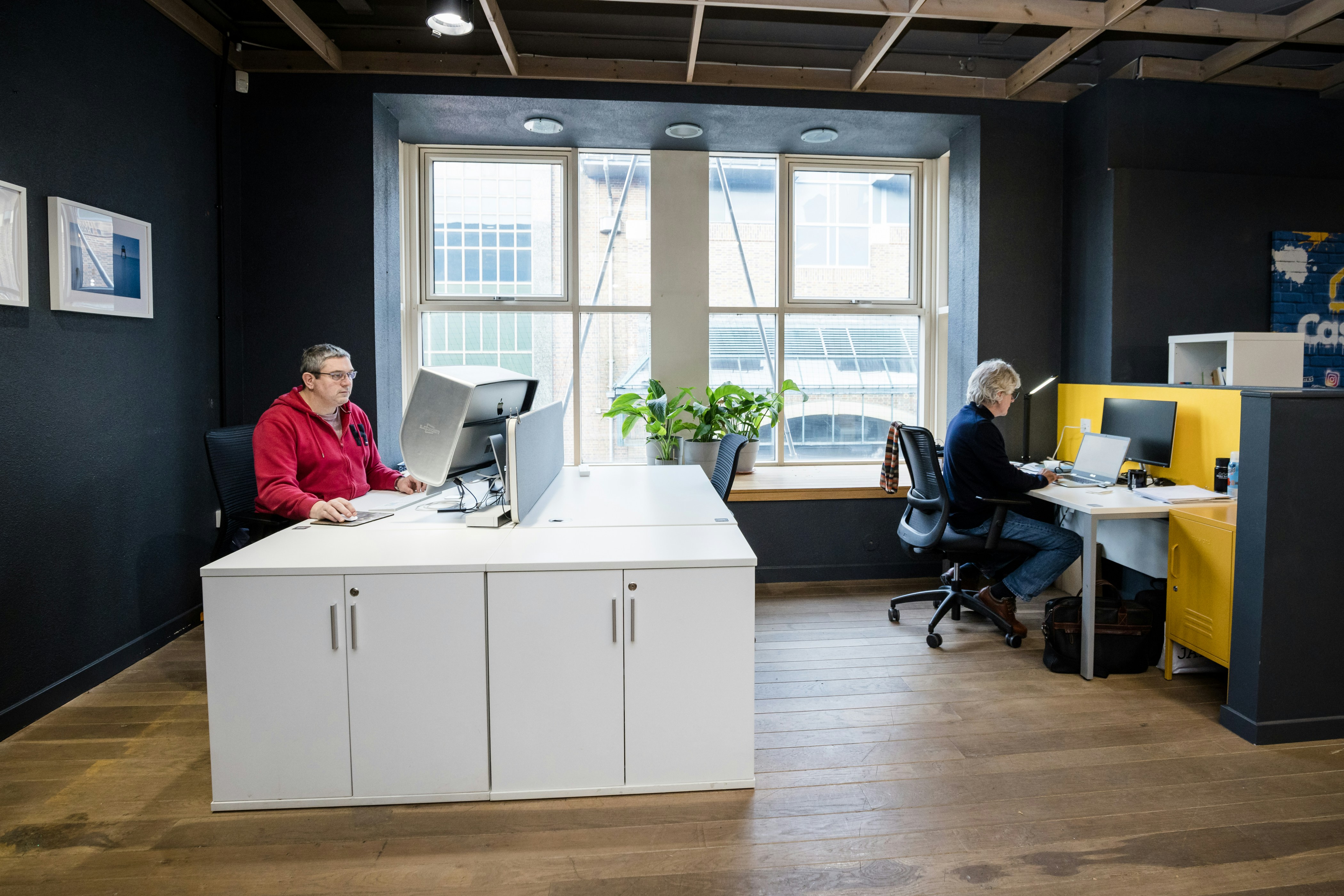 two people sitting at a desk in an office