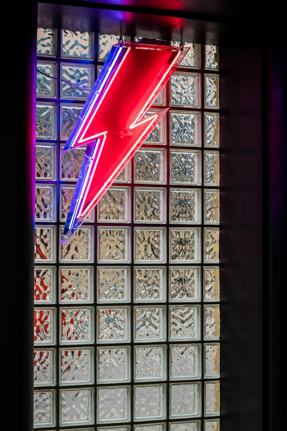 a red neon sign hanging from the side of a window