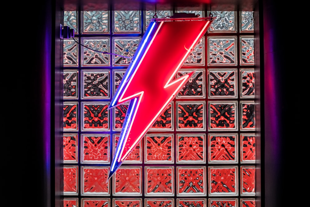 a red and blue neon sign in front of a window