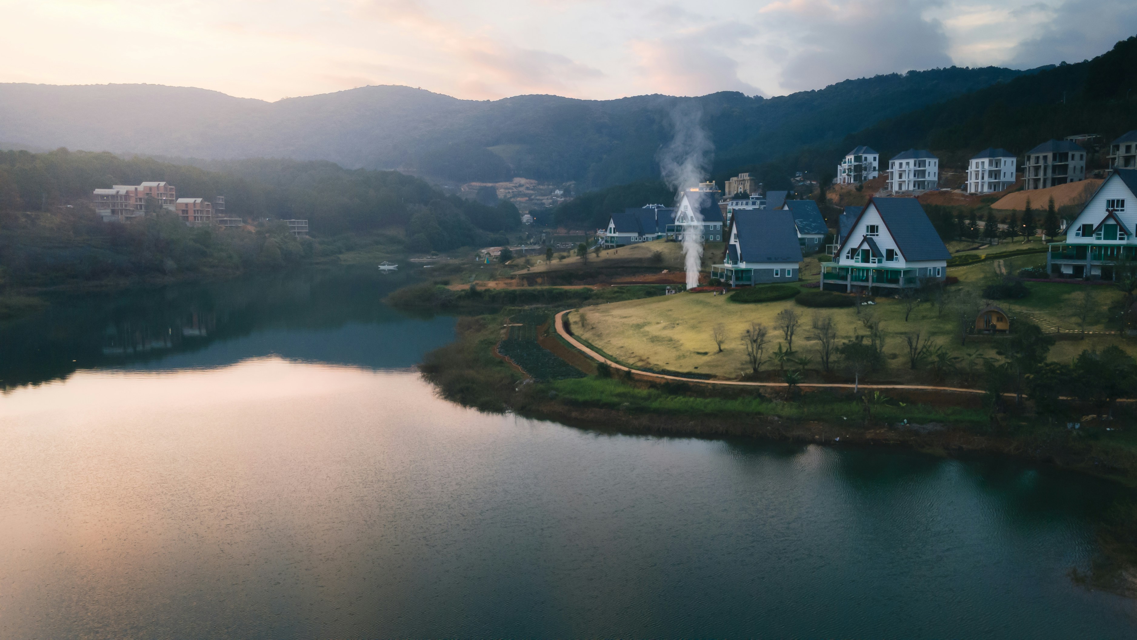 Ein Gewässer, umgeben von einem üppigen grünen Hügel