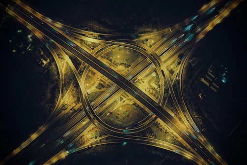 Night view of a lit-up highway interchange showcasing complex engineering and smooth traffic flow.