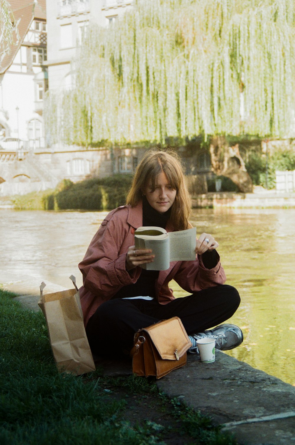 a woman sitting on the ground reading a book