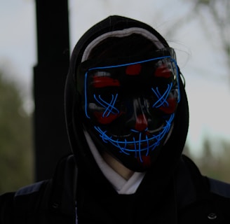 a person wearing a neon mask and a black jacket