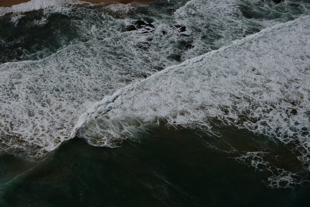 an aerial view of a body of water with waves