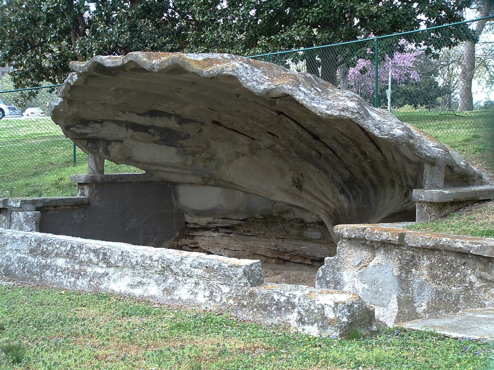 a large rock sitting on top of a lush green field