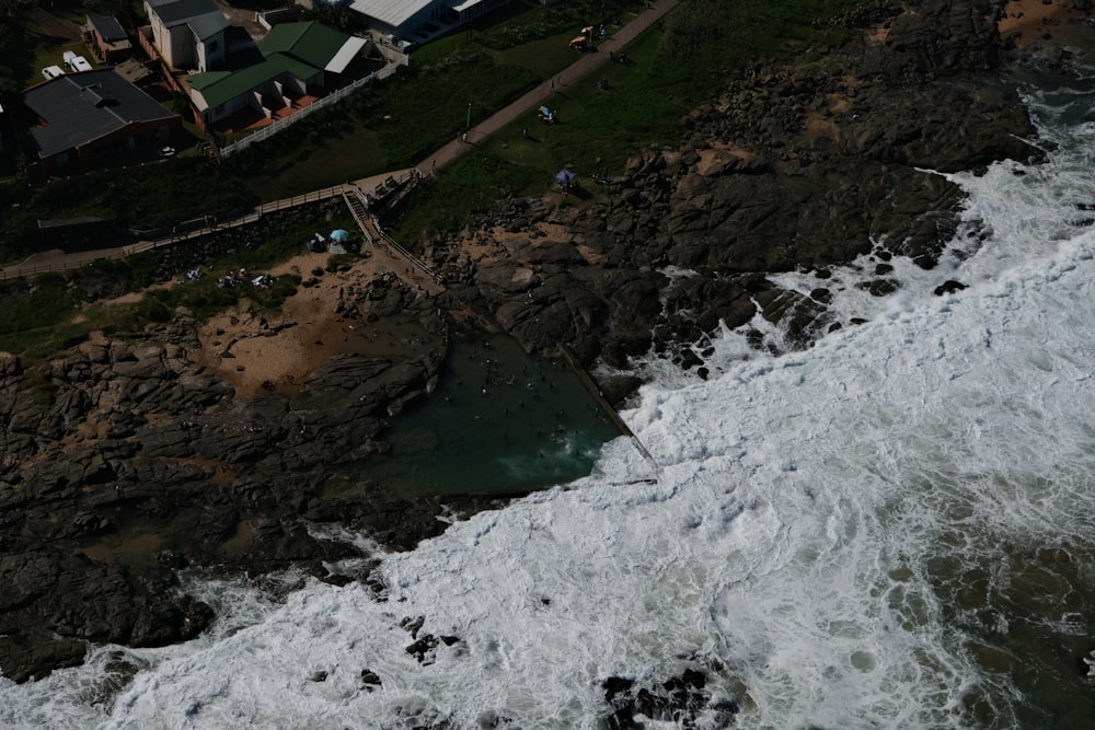 an aerial view of the ocean with houses in the background