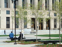 two people sitting on a bench in front of a building
