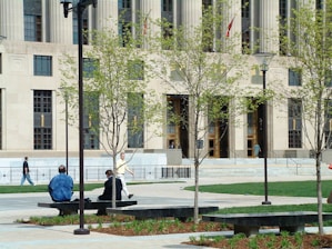 two people sitting on a bench in front of a building