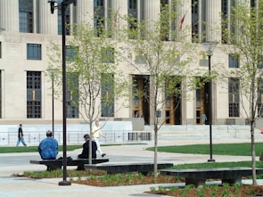 two people sitting on a bench in front of a building
