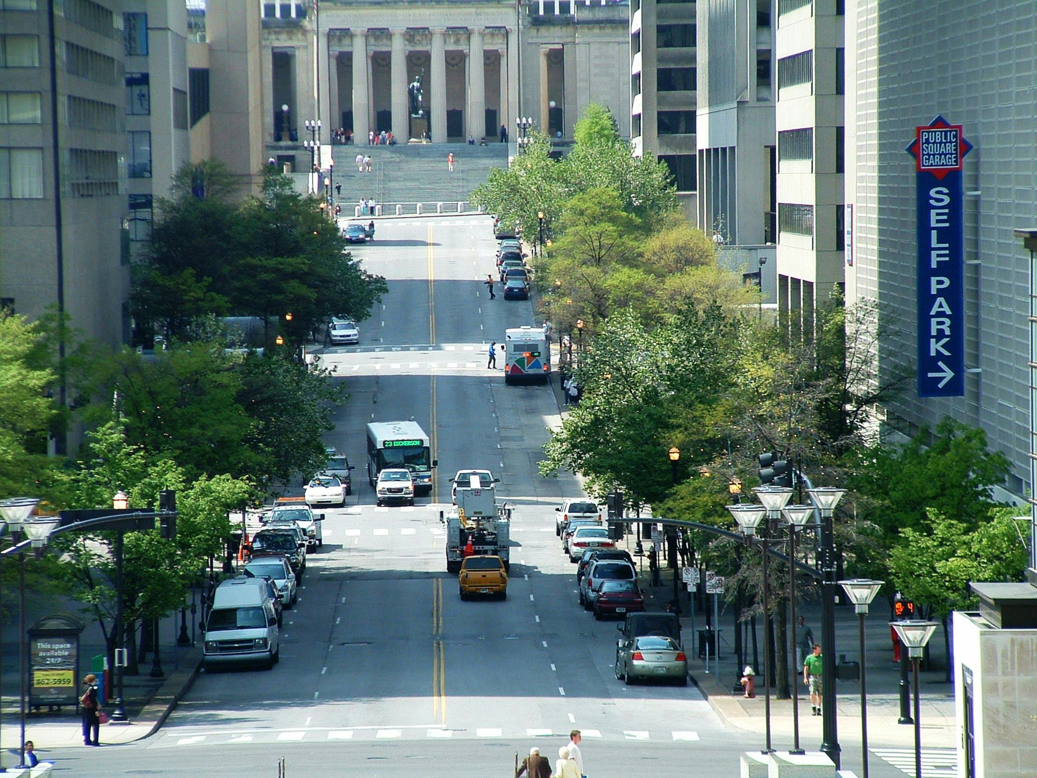 a city street filled with lots of traffic next to tall buildings