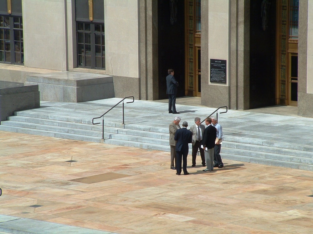 a group of men standing in front of a building