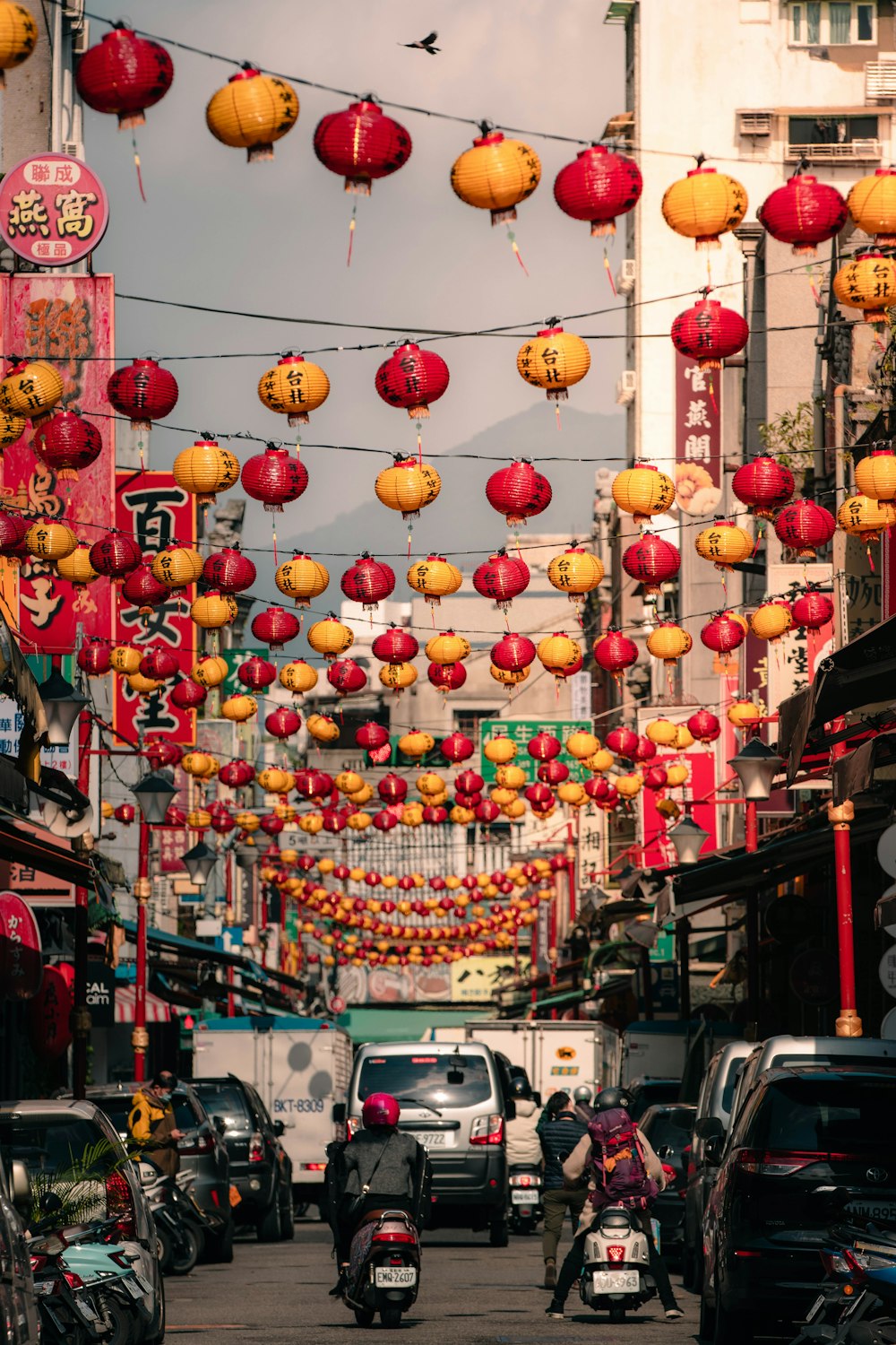 a city street filled with lots of red and yellow lanterns