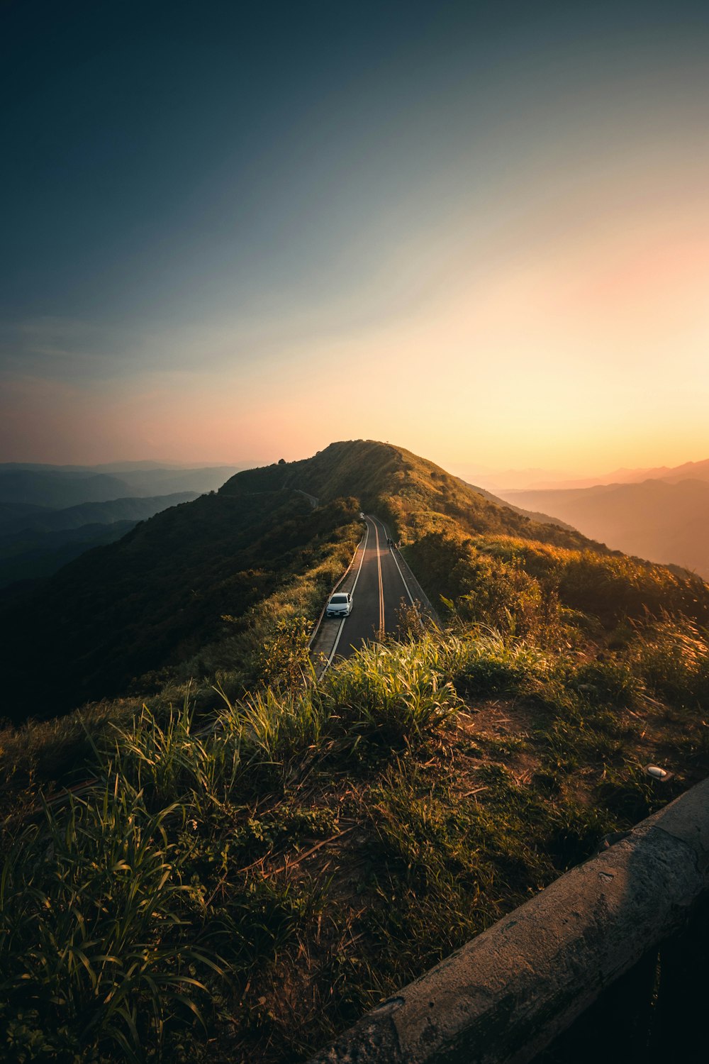 a car driving down a road on top of a hill