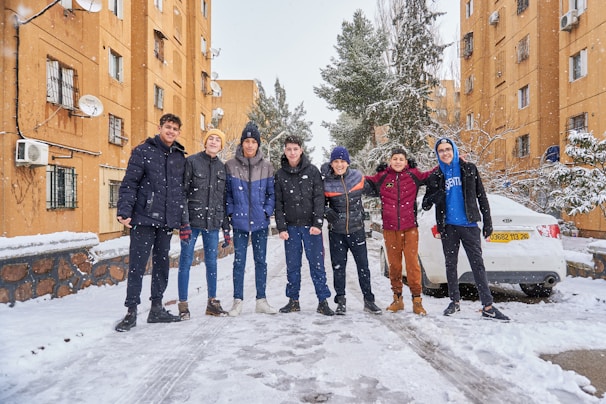 A group of friends enjoying winter activities, all dressed in fashionable jackets.