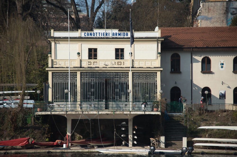 a white building with a balcony next to a body of water