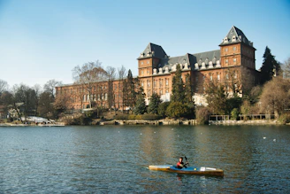 a person in a kayak in front of a large building