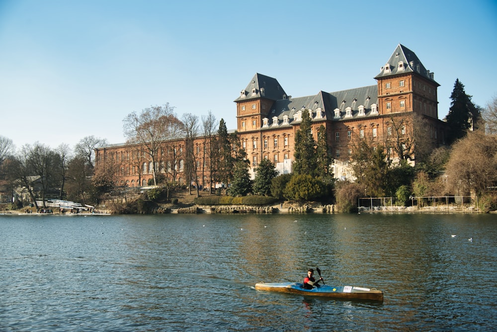 a person in a kayak in front of a large building