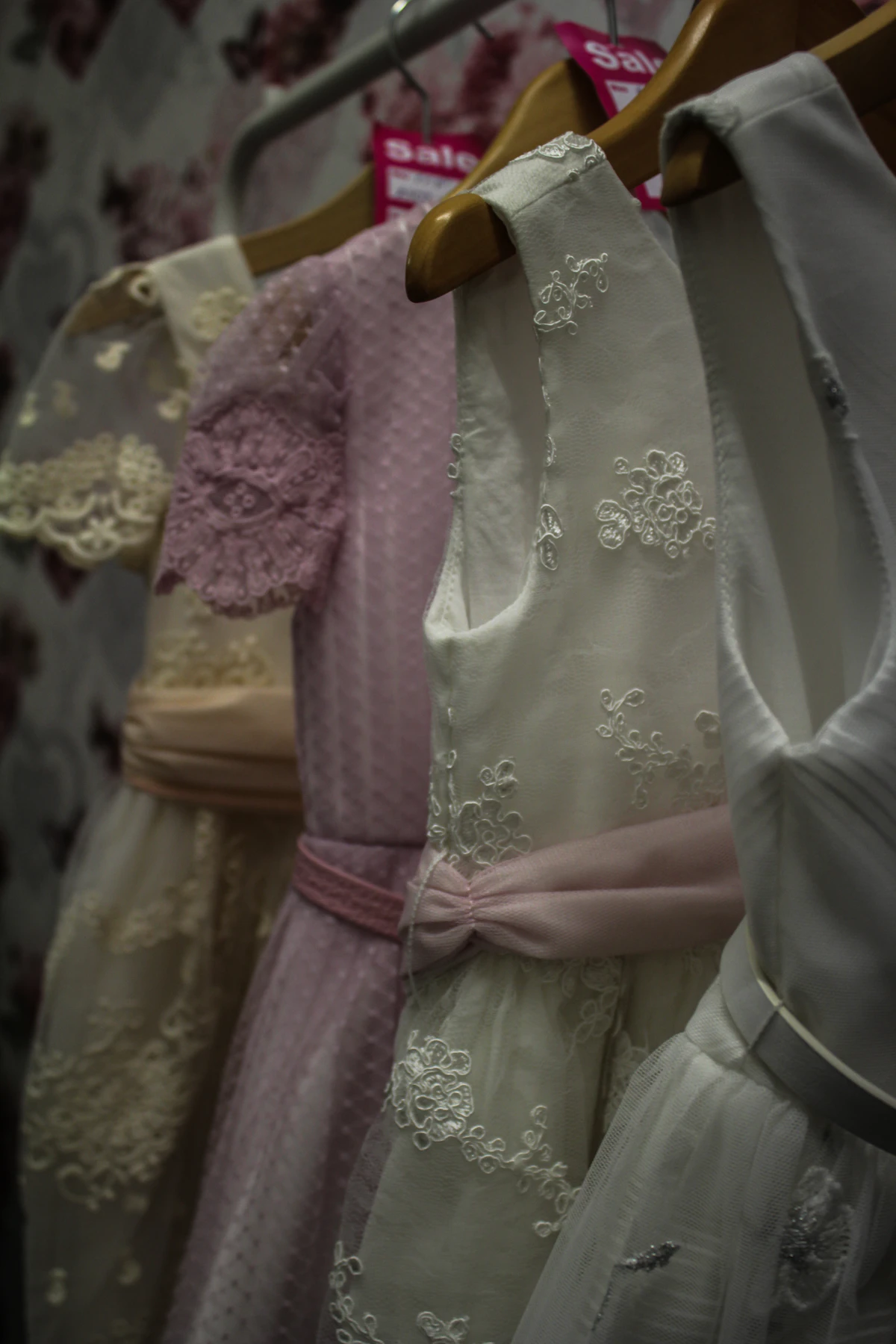 Pale dresses hanging on wooden hangers