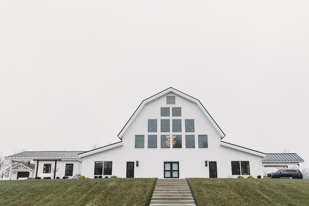 a large white barn with stairs leading up to it