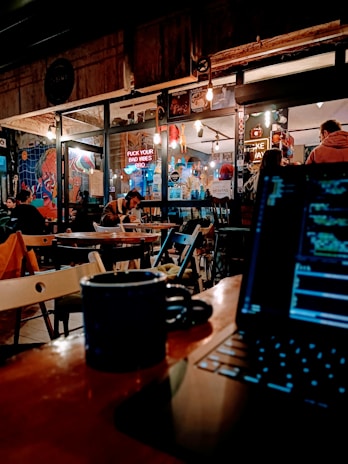 A stylish coffee shop scene with people engaging on laptops.