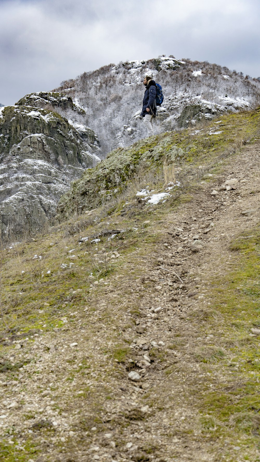 a man walking up a hill with a backpack