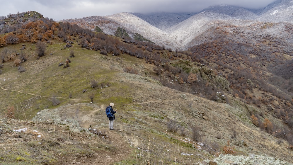 a person walking up a hill with a backpack