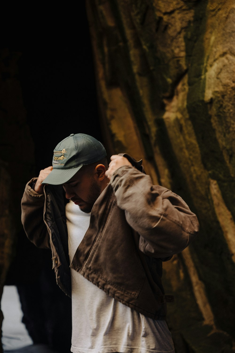 a man standing in front of a rock formation