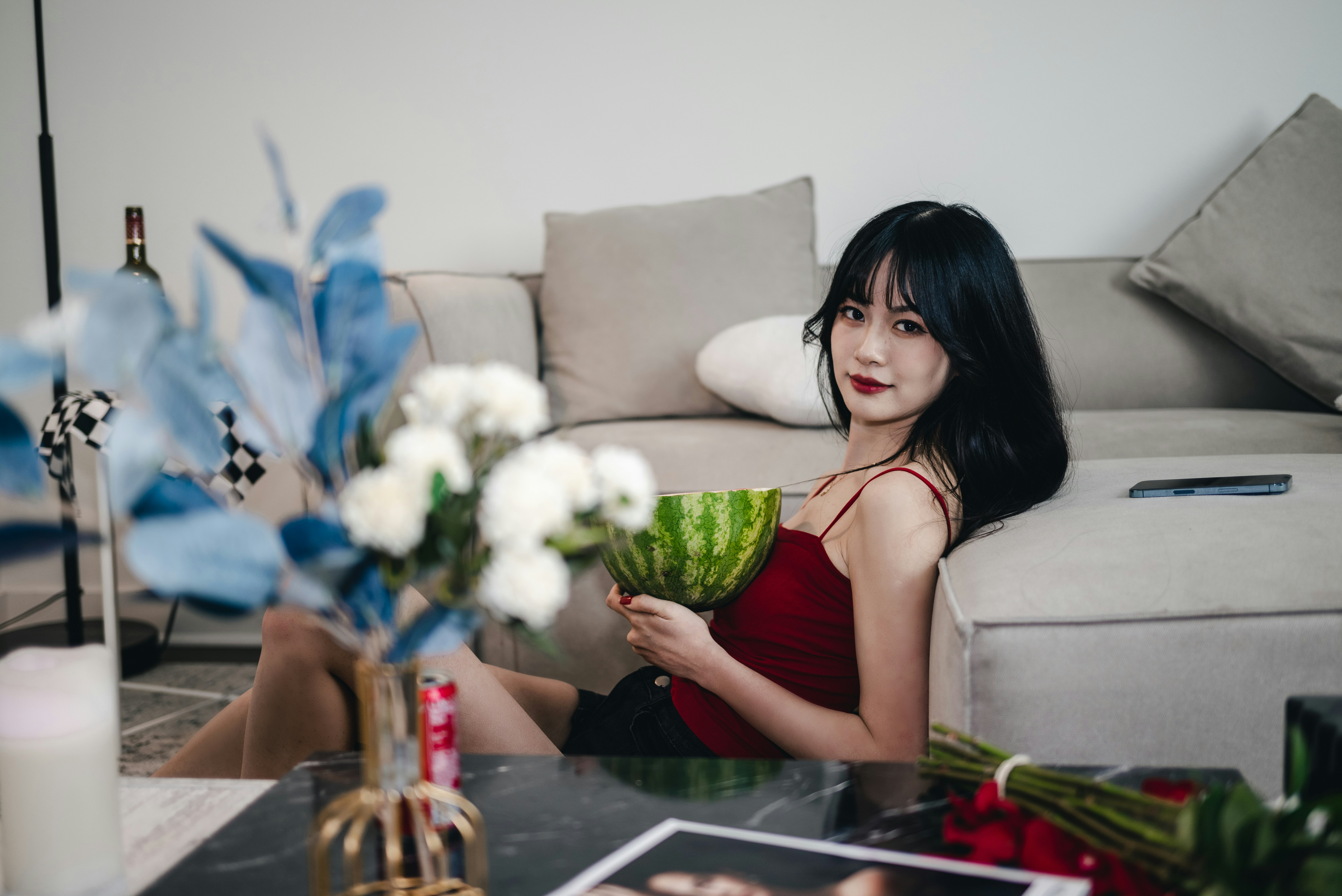 a woman sitting on a couch holding a watermelon