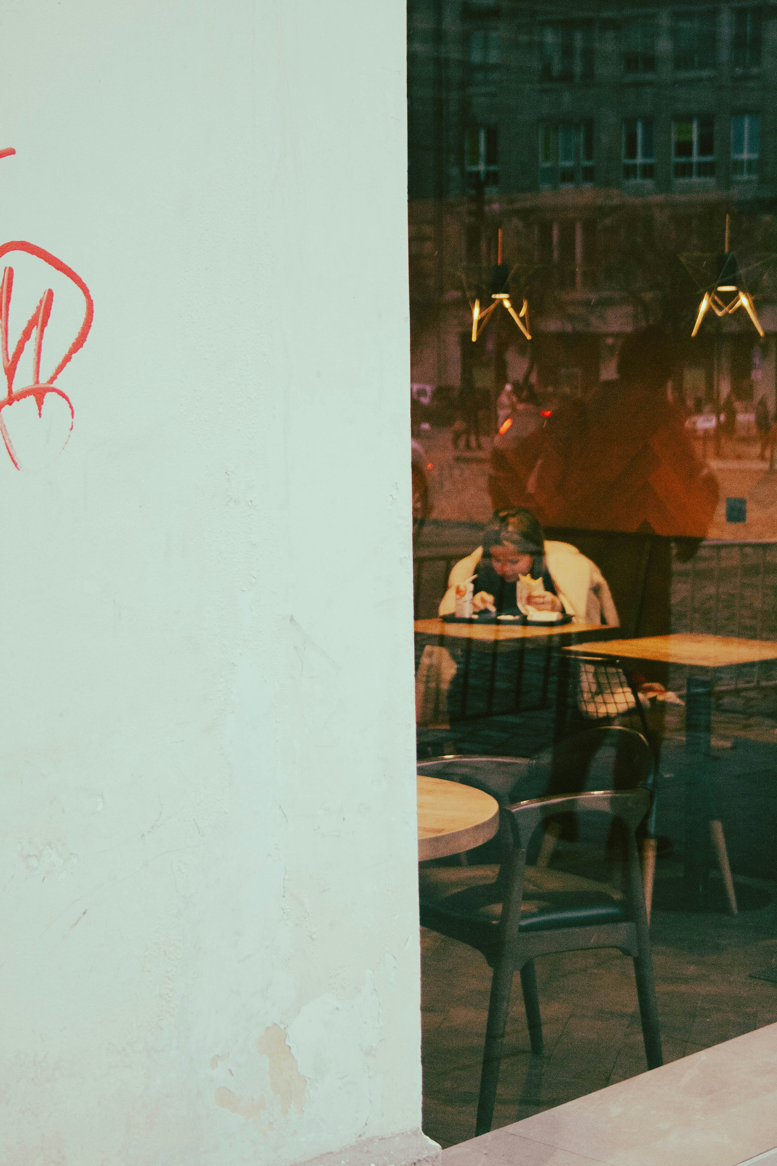 A man sitting at a table in front of a window photo Free Cafe Image