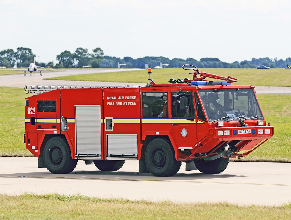 a red fire truck driving down a street