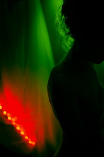 a woman standing in front of a green and red light