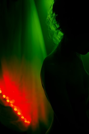 a woman standing in front of a green and red light