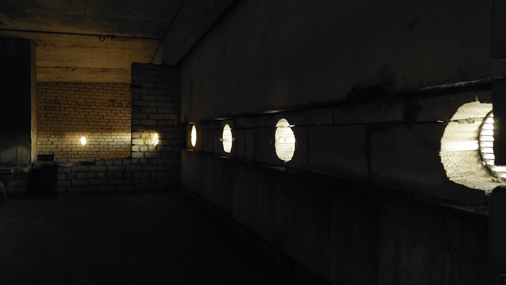 a dimly lit room with round windows and a brick wall