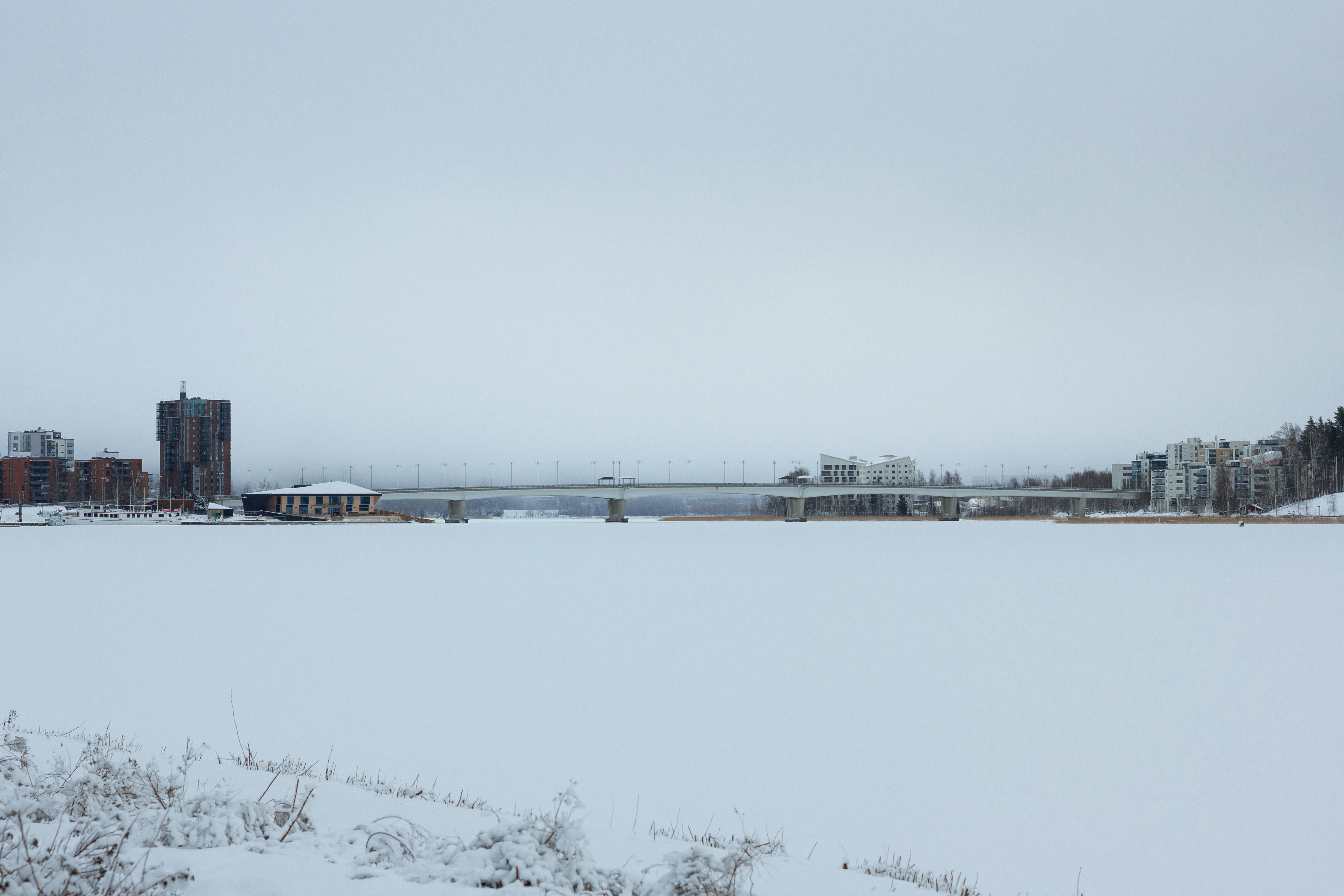 a large body of water with a bridge in the background