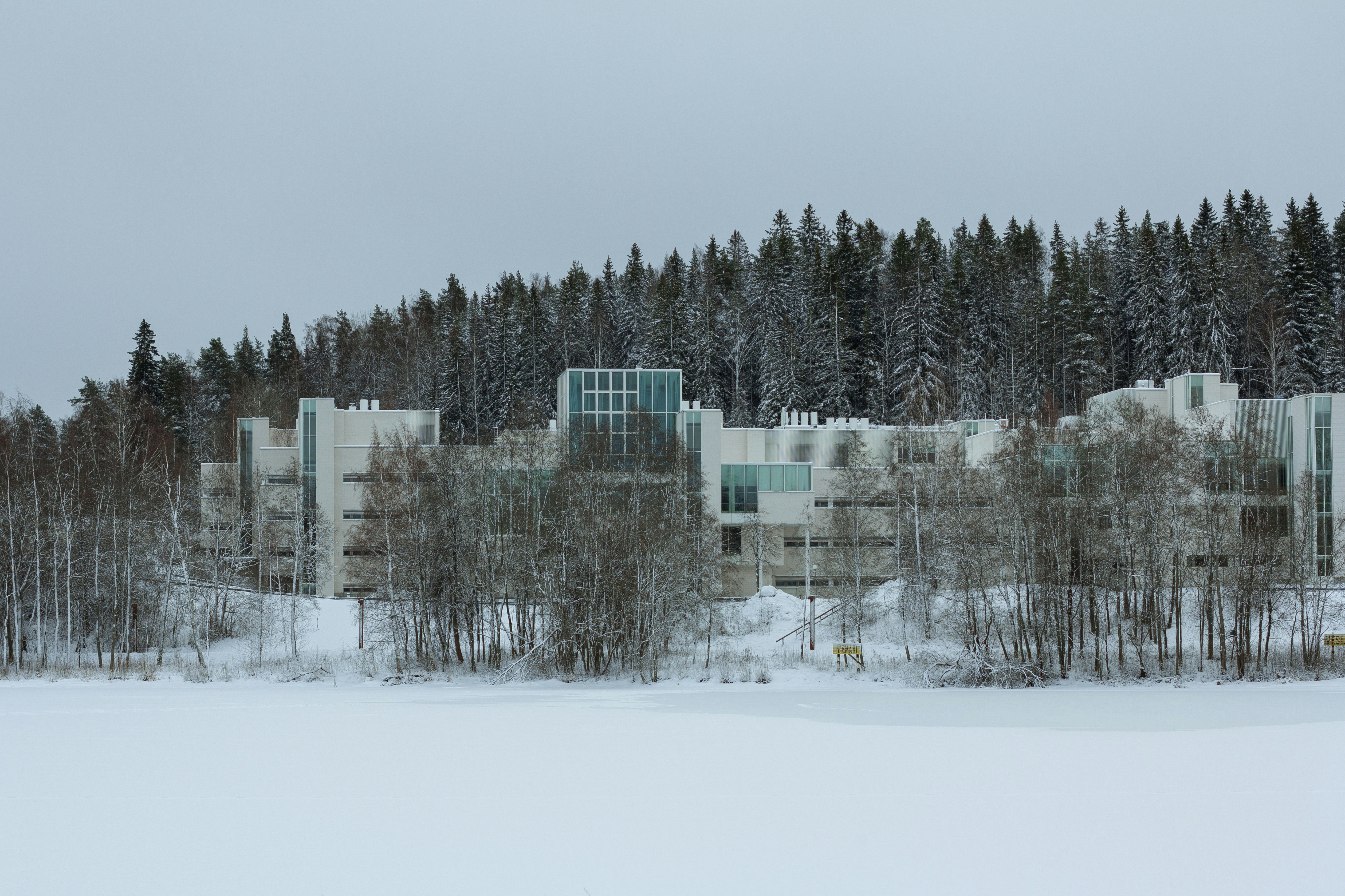 a building surrounded by trees in the snow