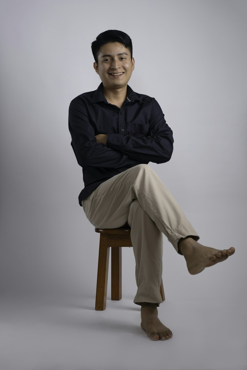 a man sitting on top of a wooden stool