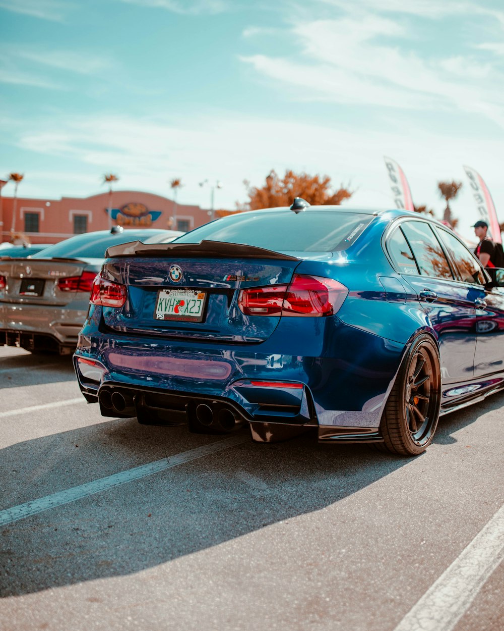 a blue car parked in a parking lot next to other cars