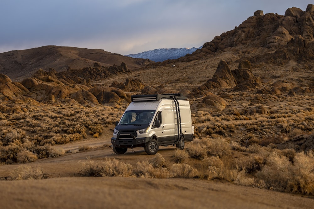 a white van parked in the middle of a desert