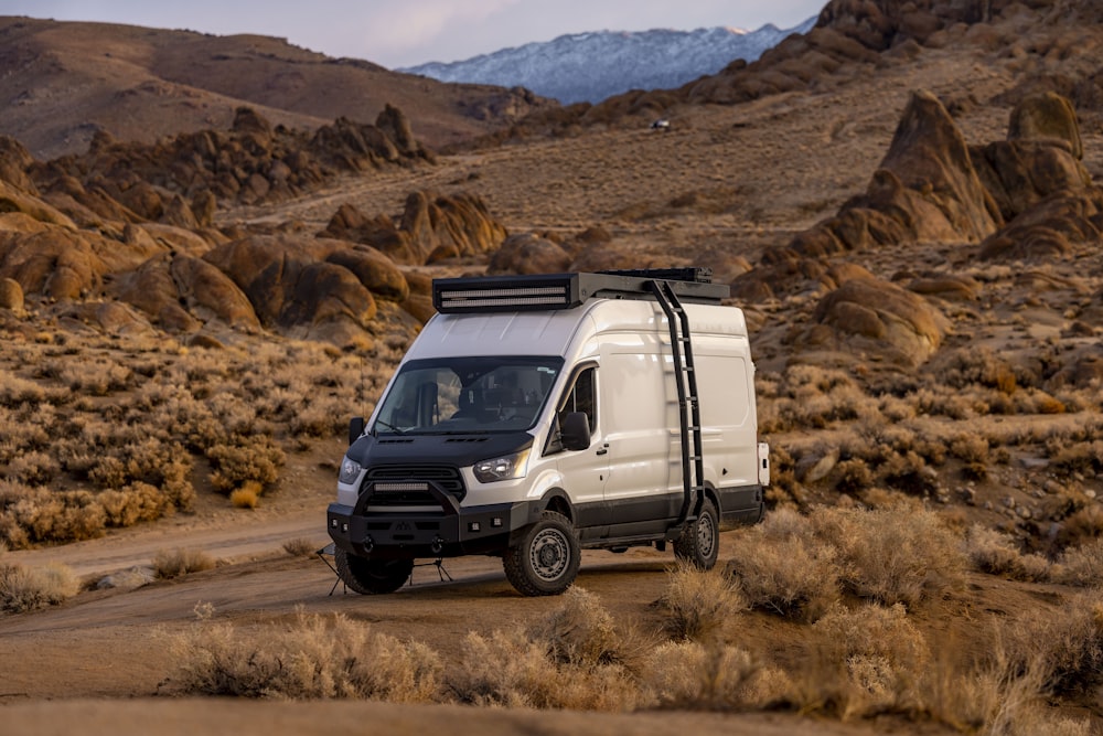 a white van driving down a dirt road