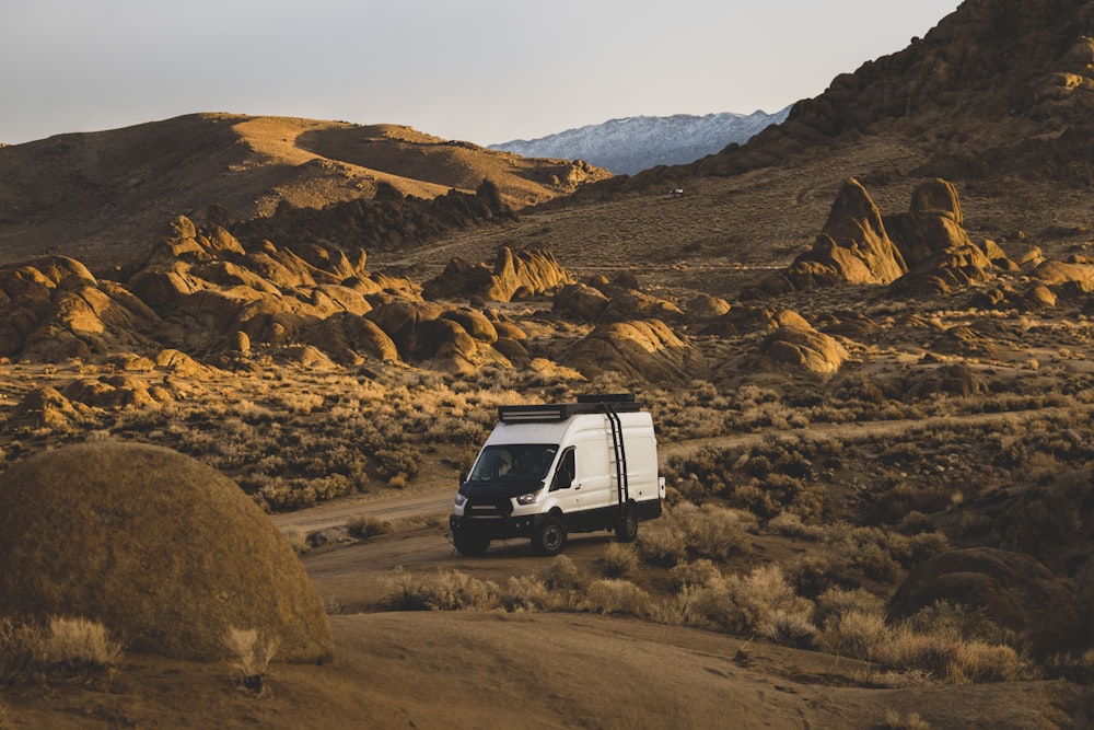 a white van driving down a dirt road